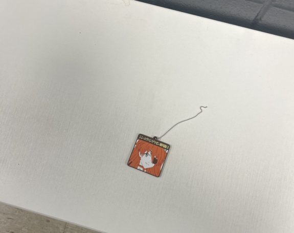 The keychain of Asuka is lying on a white bench.