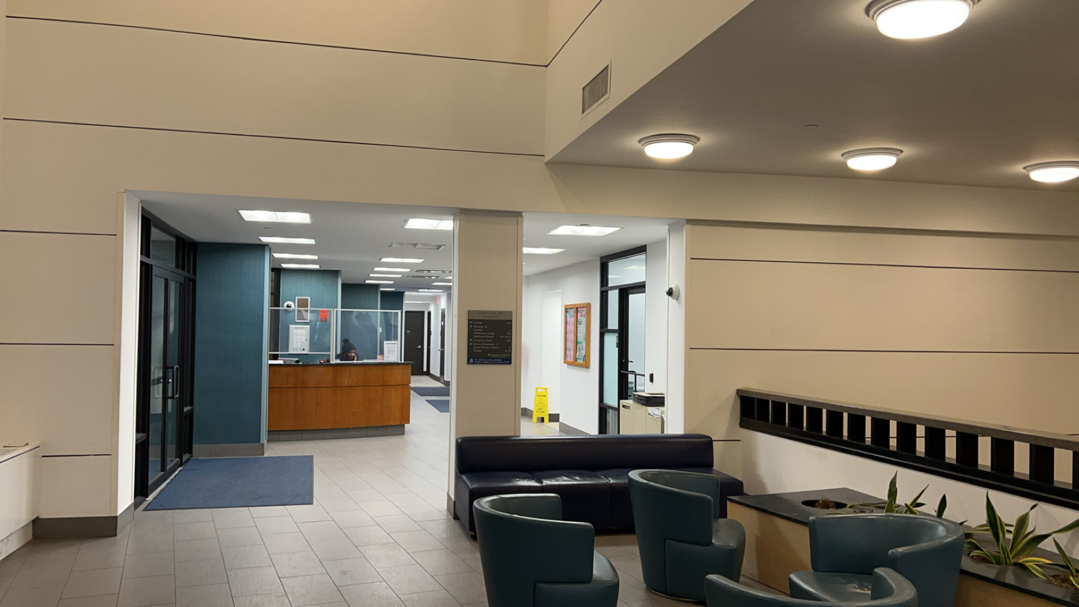 A photo of a dorm lobby with white walls sectioned in rectangles.